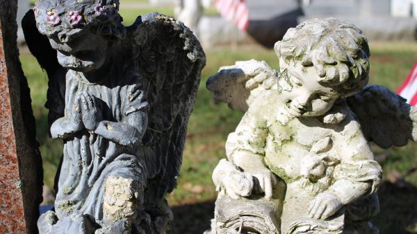 two little angel boy statues praying and reading the bible