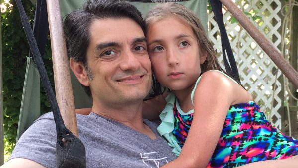 John and daughter Anna in an air chair. John smiles, Anna looks sad